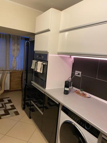 a kitchen with a white counter and a washer at Federal Luxury in Drobeta-Turnu Severin