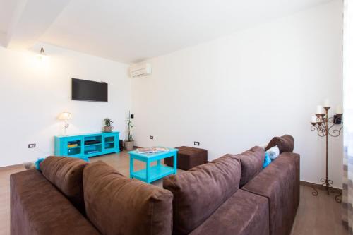 a living room with a brown couch and a blue table at Villa Roza in Central Istria with whirlpool and playground for kids - pet friendly in Tinjan