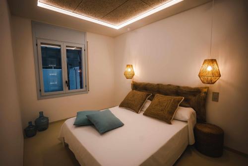 1 dormitorio con 1 cama con 2 almohadas y 2 luces en Casa Gavilán En Riumar, en Riumar