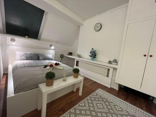 a white bedroom with a bed and a table at Modern cosy studio in Barbican - Green - F2 in London