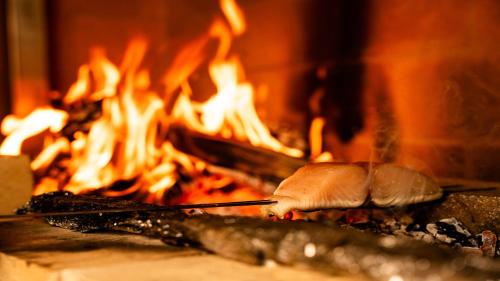 a person cooking food in front of a fire at Sengokubara COCON in Hakone