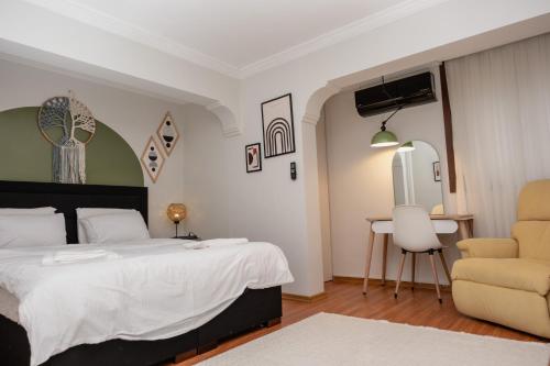 a bedroom with a bed and a chair and a table at Central & Cosy Flat near Aegean Sea Bostanlı Cemal Gürsel in Karşıyaka