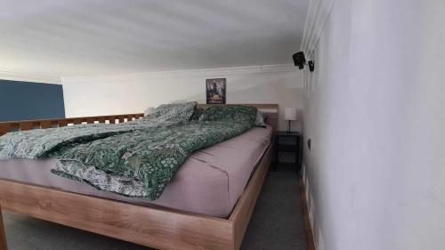 a bedroom with a bed with a green comforter at Hookah Apartment 13 in Budapest
