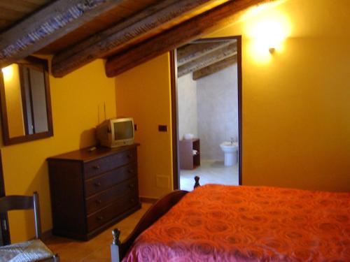 een slaapkamer met een bed en een tv op een dressoir bij Il Girasole in Mombaruzzo