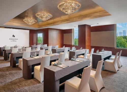 a dining room with tables and chairs and chandeliers at Marco Polo Wuhan in Wuhan