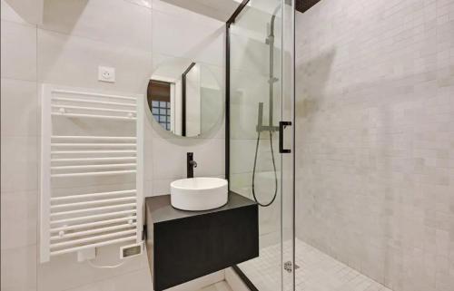 une salle de bain blanche avec un lavabo et un miroir dans l'établissement Charming Appartements for 4 people – Le Marais, à Paris