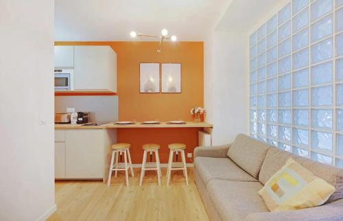 un salon avec un canapé et une cuisine dans l'établissement Charming Appartements for 4 people – Le Marais, à Paris