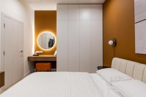 a bedroom with a white bed and a mirror at FORUM apart in Lviv