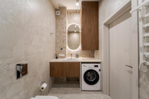 a bathroom with a washing machine and a sink at FORUM apart in Lviv