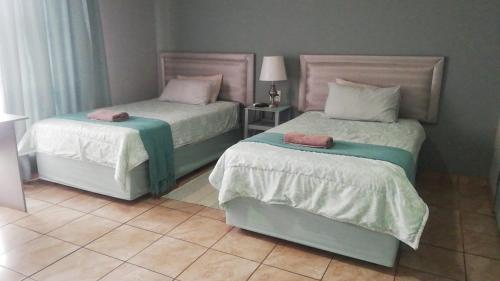 a bedroom with two beds with towels on them at Apollo Guest House in Mahikeng