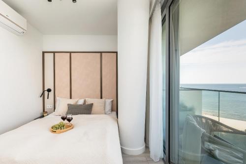um quarto com uma cama com uma bandeja de frutas em Gryfa Pomorskiego Sea View Apartment with parking by Rent like home em Międzyzdroje
