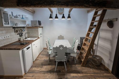 cocina con mesa, sillas y escalera en Százéves ház - Vérteskozma 48, en Gánt