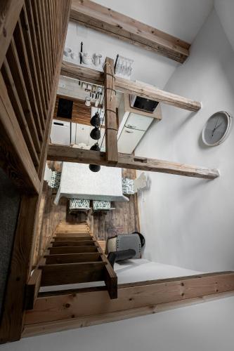 a staircase in a room with wooden beams at Százéves ház - Vérteskozma 48 in Gánt