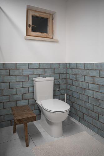 a bathroom with a toilet and a small window at Százéves ház - Vérteskozma 48 in Gánt