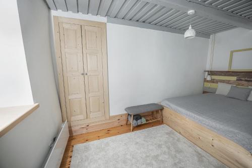 a small bedroom with a bed and a door at Százéves ház - Vérteskozma 48 in Gánt