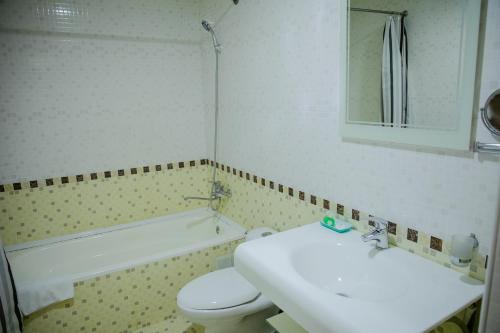 a bathroom with a sink and a toilet and a tub at Majestic Palace Hotel in Samarkand