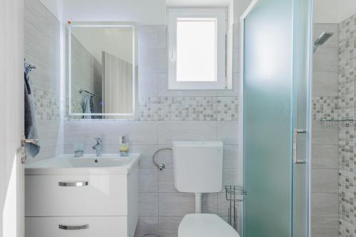 a white bathroom with a toilet and a sink at Villa Vera in Benkovac