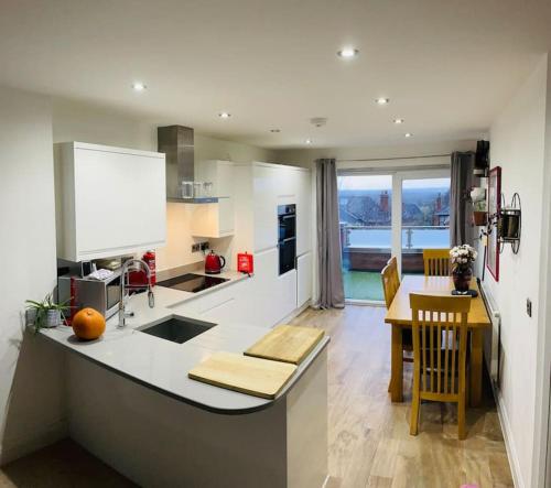 a kitchen with a counter and a table in it at Balcony views + Parking in Lincolnshire