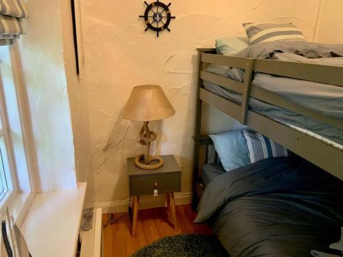 1 dormitorio con litera y mesa con lámpara en Grooms cottage, a tranquil Cornish retreat en Lanteglos