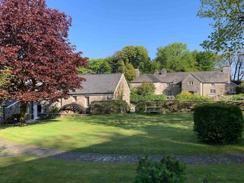 una casa grande con un gran patio delante en Grooms cottage, a tranquil Cornish retreat en Lanteglos