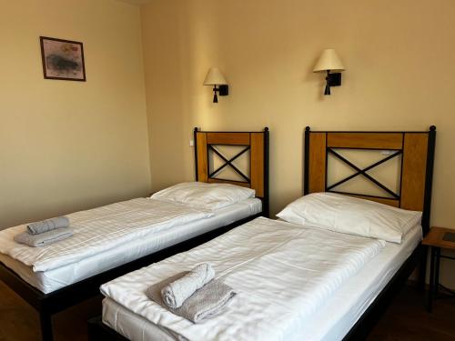 two beds in a hotel room with white sheets at Penzion LaCasa in Vysoké Mýto