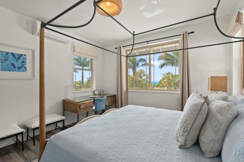 een slaapkamer met een bed, een bureau en een raam bij Aloha Breeze by AvantStay Ocean View Near Beach in Waianae