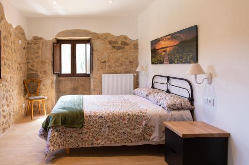 um quarto com uma cama e uma cadeira num quarto em O Rincón de Esther em Vedra