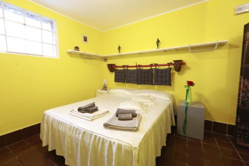 um quarto amarelo com uma cama com toalhas em Lo studio di Podere Bellavista em Monteprandone