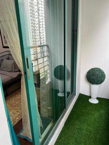 Pokój z oknem z zielonym dywanem i wazami w obiekcie Millennium Plaza Hotel w mieście Manila