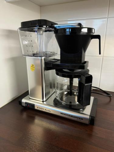 a coffee maker sitting on top of a table at Top floor flat with sauna, A/C & free parking in Vantaa