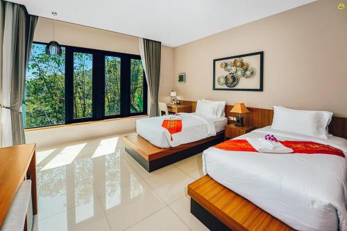 a hotel room with two beds and a window at Bangnu Greenery Resort in Takua Thung