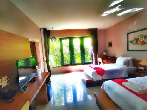 a hotel room with two beds and a television at Bangnu Greenery Resort in Takua Thung