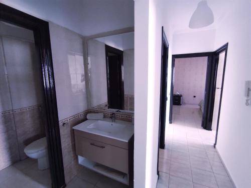 a bathroom with a sink and a toilet and a mirror at rabatapartmentresidence in Rabat