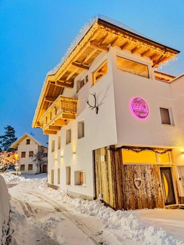 a building with a sign on it in the snow at Das Mountain Getaway - Luxury Ground Floor Stubai Super Card in Fulpmes