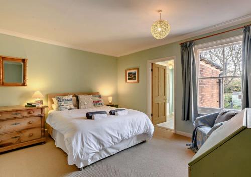 a bedroom with a bed and a large window at Bond Cottage in Overstrand