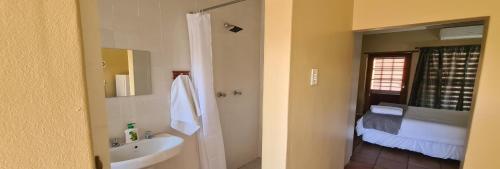 uma casa de banho com um lavatório, um WC e um espelho. em Hexberg Cottage em Wellington