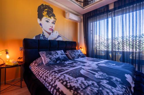 La terrasse d'Audrey - Short stay au coeur du Maarif في الدار البيضاء: غرفة نوم بسرير مع لوحة على الحائط