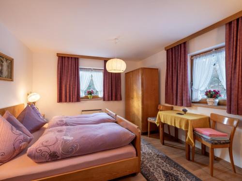 a bedroom with a bed and a desk and a table at Chalet - Appartements Julitta in Mayrhofen