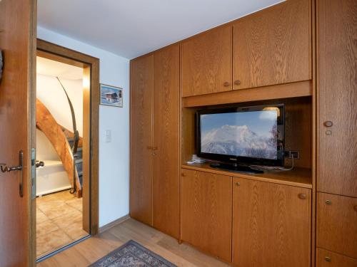 a room with a flat screen tv in a wooden cabinet at Chalet - Appartements Julitta in Mayrhofen