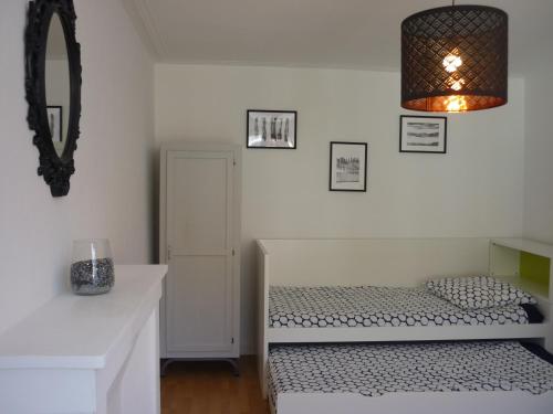 um quarto branco com uma cama e um espelho em CHU-Cité des congrès 6 personnes logement entier em Nantes