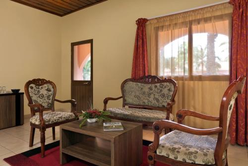 a living room with two chairs and a table at Dunia Hôtel Bissau in Bissau