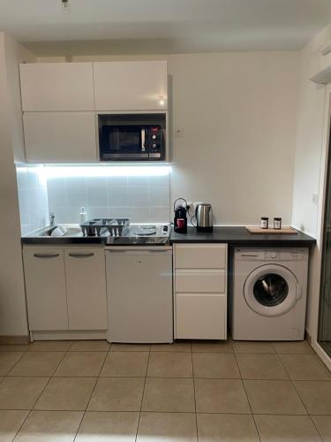a kitchen with a sink and a washing machine at Appartement Lahcen in Thorigny-sur-Marne