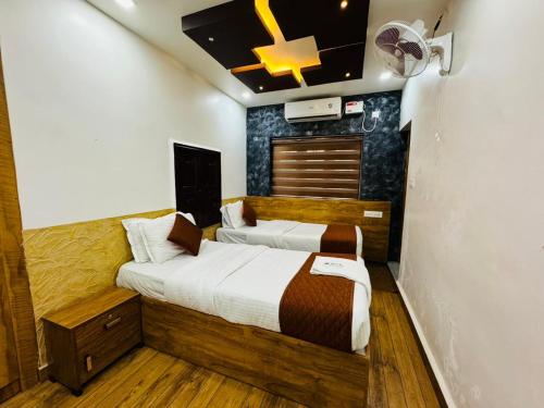 a bedroom with two beds and a ceiling fan at HERITAGE HOMES in Ernakulam