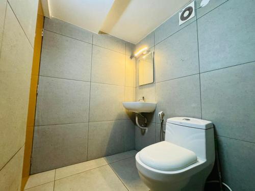 La salle de bains est pourvue de toilettes et d'un lavabo. dans l'établissement HERITAGE HOMES, à Ernakulam