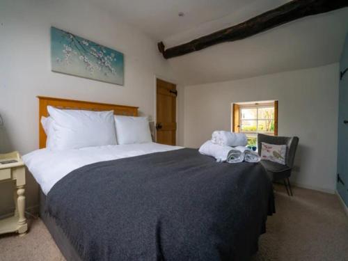 - une chambre avec un grand lit et une fenêtre dans l'établissement Pass the Keys Stylish and Spacious Cotswolds Cottage - Sleeps 6, à Lechlade