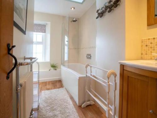 a bathroom with a bath tub and a sink at Pass the Keys Stylish and Spacious Cotswolds Cottage - Sleeps 6 in Lechlade