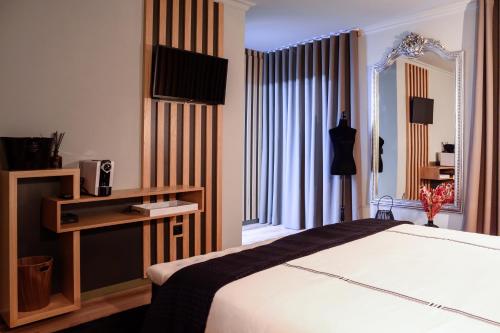 een hotelkamer met een bed en een televisie bij Boutique Wine Hotel Panorama in Macedo de Cavaleiros