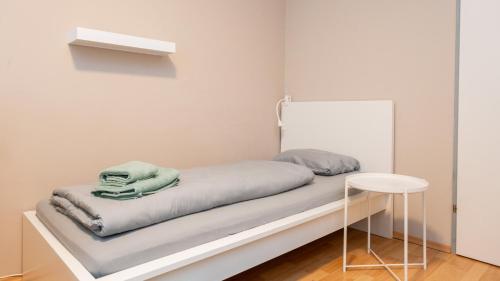 un letto d'ospedale con una coperta verde e uno sgabello di Zimmer 1230 a Vienna