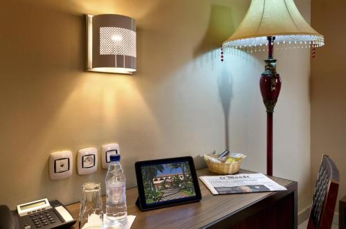 a desk with a lamp and a phone on a table at Dunia Hôtel Bissau in Bissau