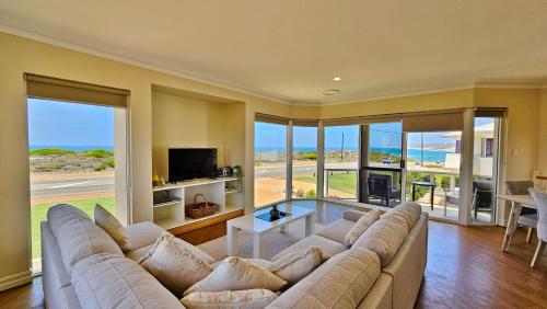 a living room with a large couch and a television at Kingview 2 - Kalbarri WA in Kalbarri